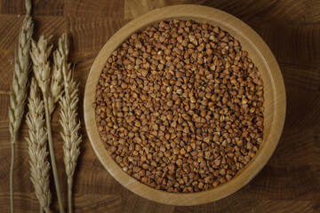 Buckwheat on a wooden board. Buckwheat on top. Buckwheat in a bowl. Cereals