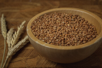 Buckwheat on a wooden board. Buckwheat on top. Buckwheat in a bowl. Cereals
