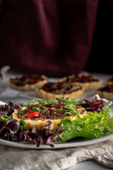Savory tarts with baby bell mushrooms, onions, and red bell peppers. All in a sauce or custard of ricotta cheese and egg and baked in a butter pie crust. Served on a bed of mixed salad greens.