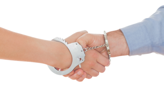 Handcuffed business people shaking hands - Powered by Adobe