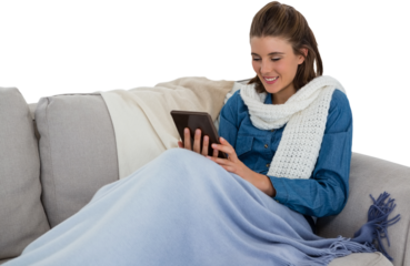 Woman using tablet computer while sitting on sofa