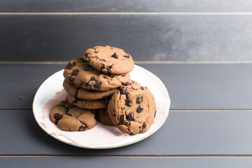 chocolate chip cookies on a plate, chocolate chip cookies on wooden table, chocolate chip cookies on a pink plate on a white wooden table