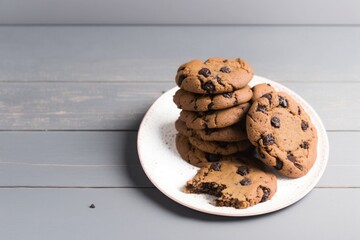 chocolate chip cookies on a plate, chocolate chip cookies on wooden table, chocolate chip cookies on a pink plate on a white wooden table