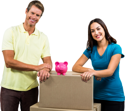 Portrait of smiling couple standing by piggy bank on box