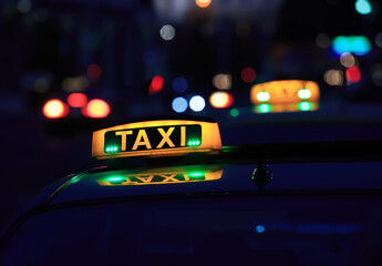 Yellow taxi lantern on the roof of the car at night