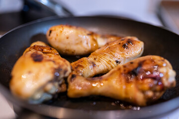 Fry chicken in a pan. Cook the drumstick in a pan.