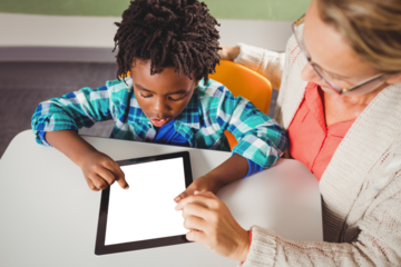Teacher and student  using digital tablet in classroom