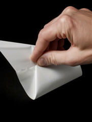 A closeup of a hand tightening its grip around a white envelope.. AI generation.