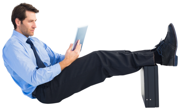 Businessman sitting using tablet with feet on his briefcase