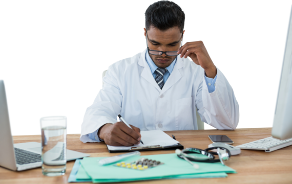 Doctor writing on clipboard at desk
