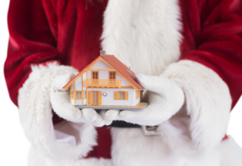 Santa holds a tiny house in his hands