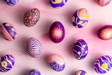 Pattern made of beautiful Easter eggs painted in pink, lilac and violet colors with unique design...