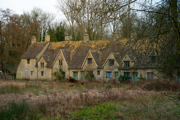 Iconic row of medieval stone built cottages in the picturesque village of Bibury in Cotswolds, England