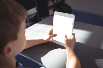 Boy using tablet computer at desk