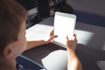 Boy using tablet computer at desk