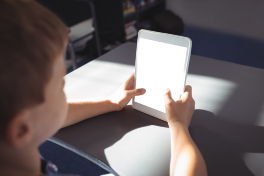 Boy using tablet computer at desk