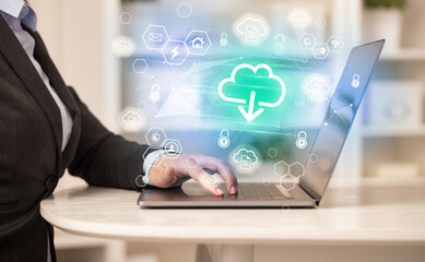 Hands working on laptop with digital icons