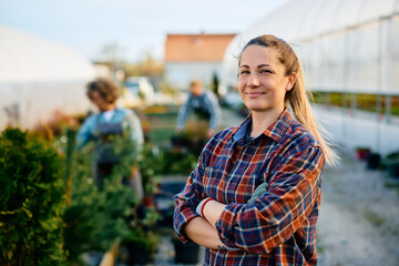 Confident small business owner at her greenhouse looking at camera.