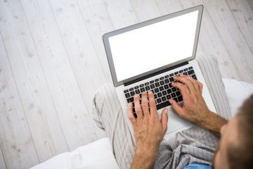 Overhead view of a man using laptop in living room