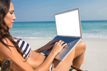 Pretty brunette using laptop on deck chair