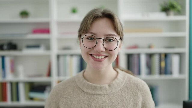 Young blonde woman student smiling confident standing at library university