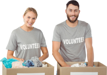 Portrait of smiling volunteers separating donations clothes 