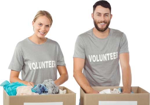 Portrait of smiling volunteers separating donations clothes 
