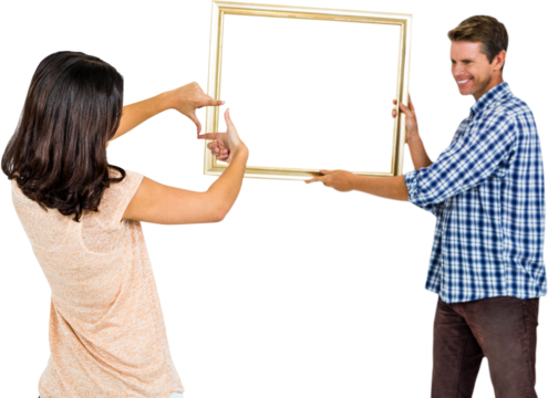 Happy young couple hanging picture frame