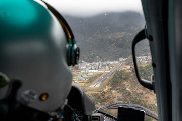 Interior photo of a Nepali helicopter pilot preparing to safely land on Lukla airstrip