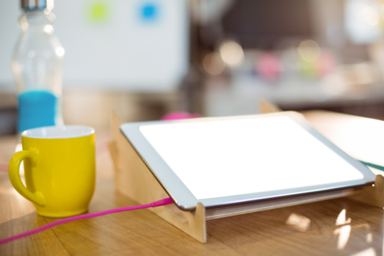 Digital tablet and a cup of coffee on table