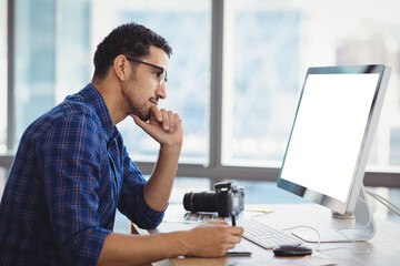 Attentive graphic designer using graphic tablet at desk