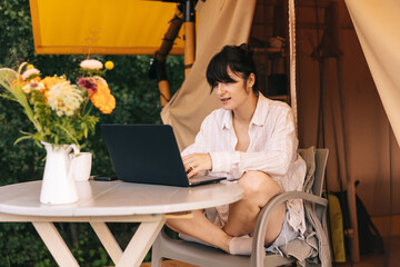 Happy young woman tourist sitting in touristic tent at summer time © Ananass
