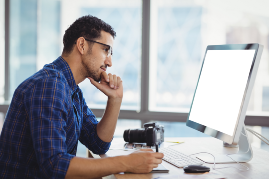 Attentive graphic designer using graphic tablet at desk