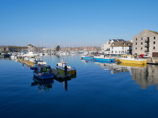 Fototapeta na wymiar Boats in the old town of Weymouth Harbour and Weymouth Marina in Dorset, England, UK