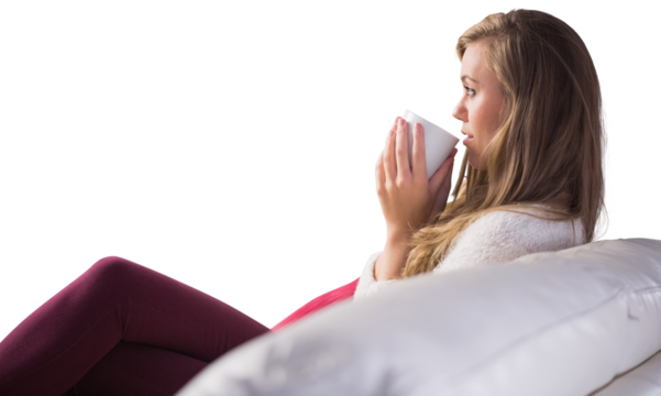Pretty blonde relaxing on the couch with tea