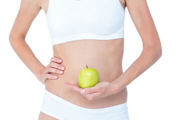 Woman holding an apple in front of her belly 