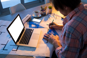 Male architect working on blueprint at desk
