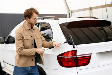 Young handsome man clearing car