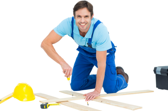 Happy repairman fixing screw on plank