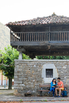 Asturias historical building Villanueva heritage. Mixed race couple together outdoor with tablet
