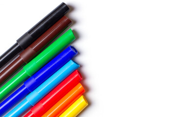 Markers of different colors lie in a row. On a white background.