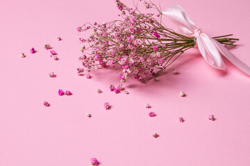 Delicate dry pink flowers. Small flowers. On a pink background. Spring, feminine, cute. Pink background. Flowers. Dried flowers. Empty space. Bouquet.