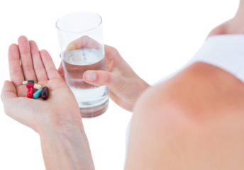 Woman holding batch of pills and glass of water