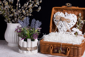 A bouquet of willow in a vase on a black background. Wicker suitcases with flowers and a bouquet of lavender, Provence