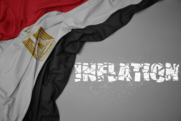 waving colorful national flag of egypt on a gray background with broken text inflation. 3d...