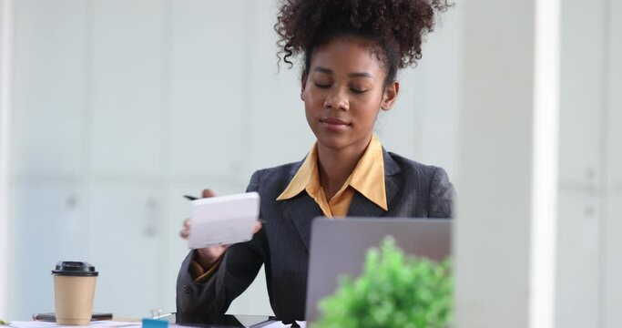 Young African American businesswoman working with pile of documents at office workplace, business finance and accounting concepts.