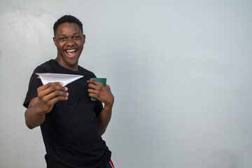 excited young black man holding a paper plane and passport