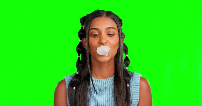Face, woman and blowing bubblegum in green screen, color background and studio. Portrait, female model and chewing gum for happiness, candy sweets and smile for gen z style, carefree attitude and fun
