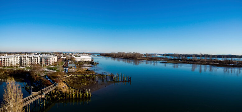 Aerial photo of historic Steveston Cannery on the Fraser River in Richmond, BC Canada with Mt. Baker in the distance