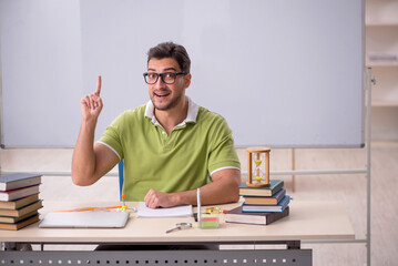 Young male student preparing for exams in the classroom